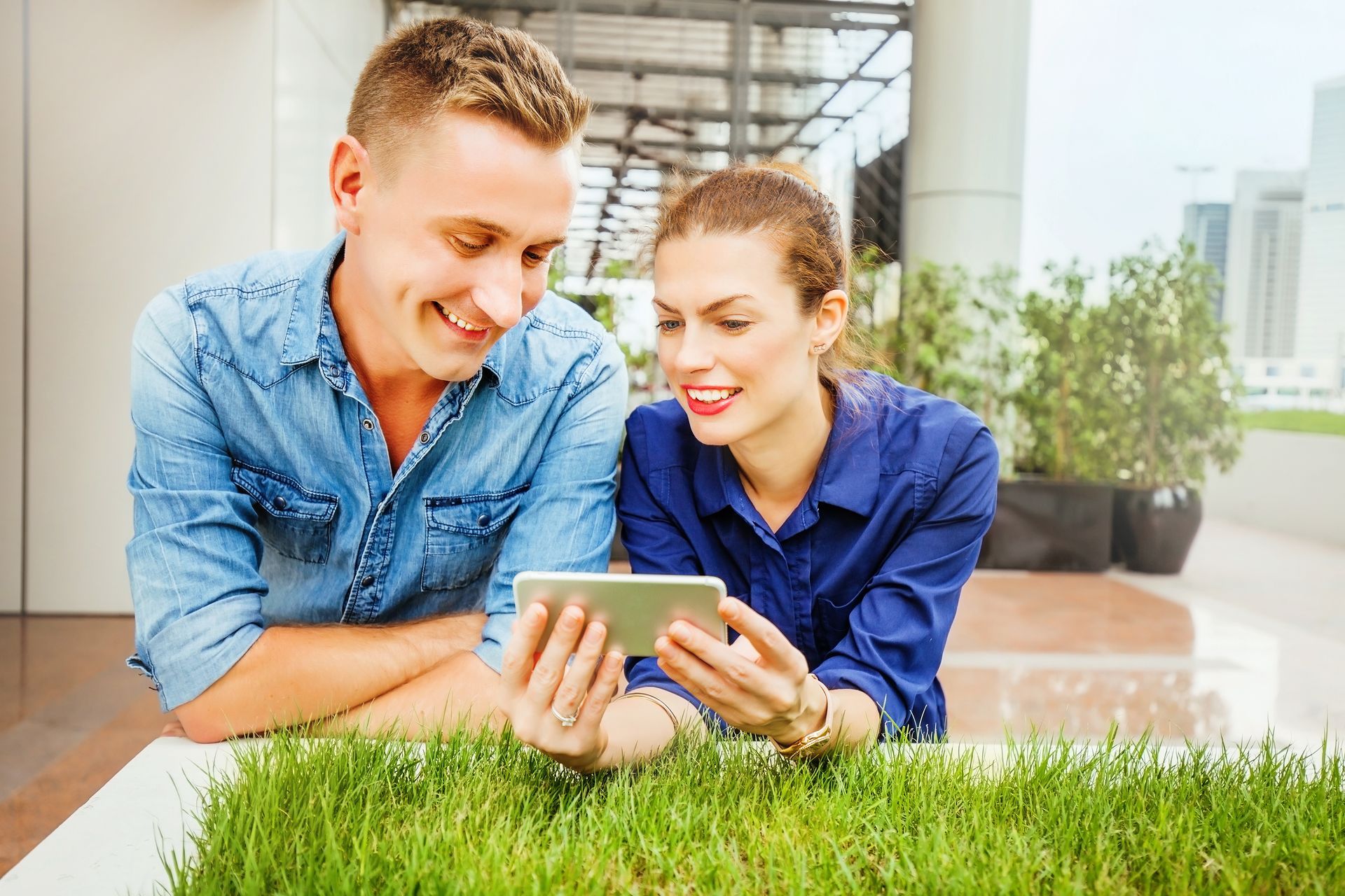 A man and a woman are looking at a tablet together.