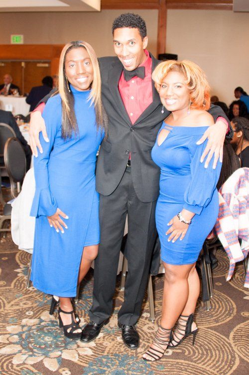 two woman in blue dress and a man in the middle