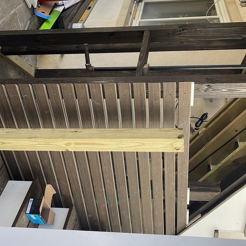 A partially constructed wooden deck and storage area, with varying shades of brown and natural wood.