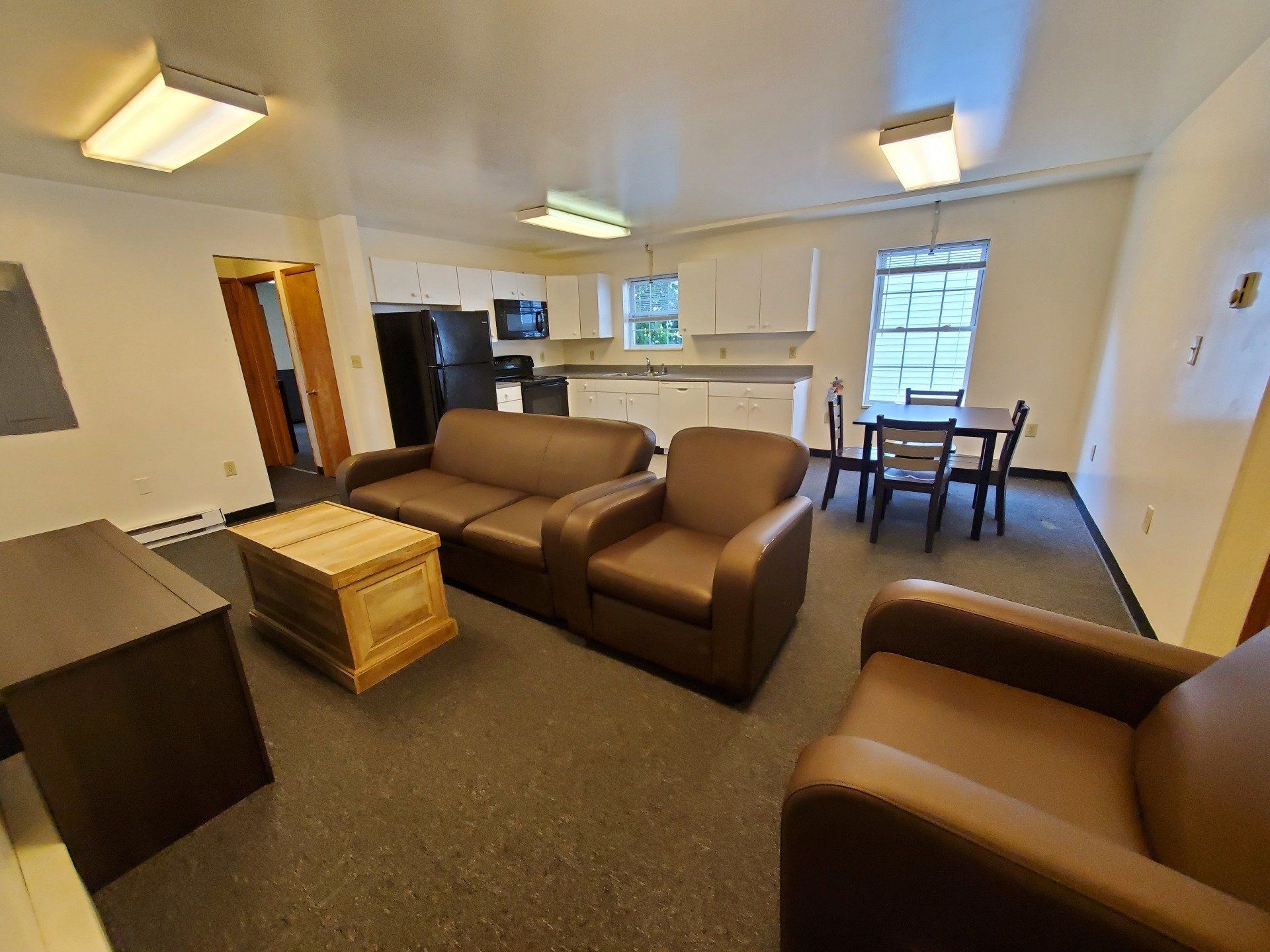 Living room with couch, chairs and view of kitchen