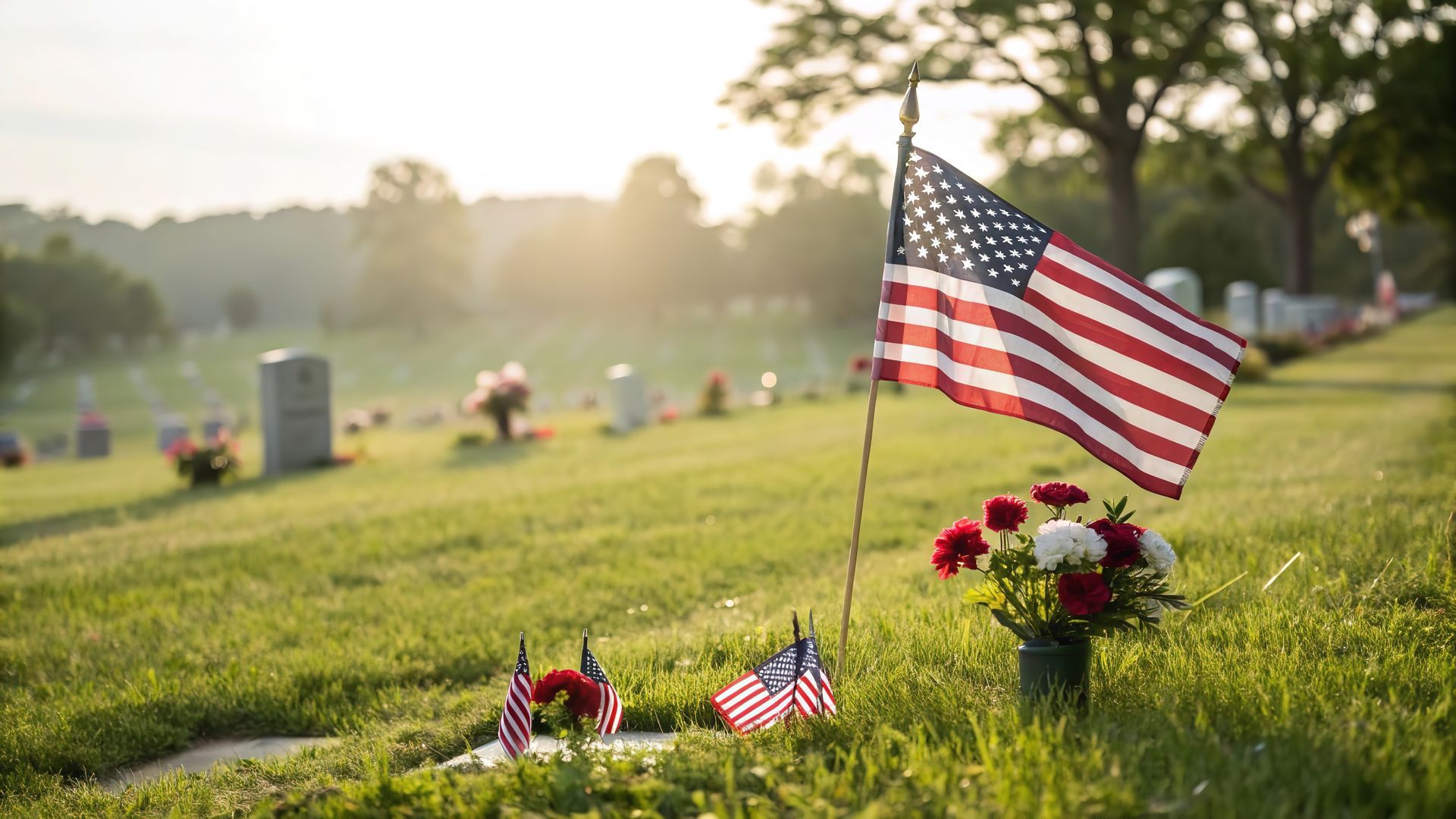 A woman is holding an american flag and a rose at a funeral.