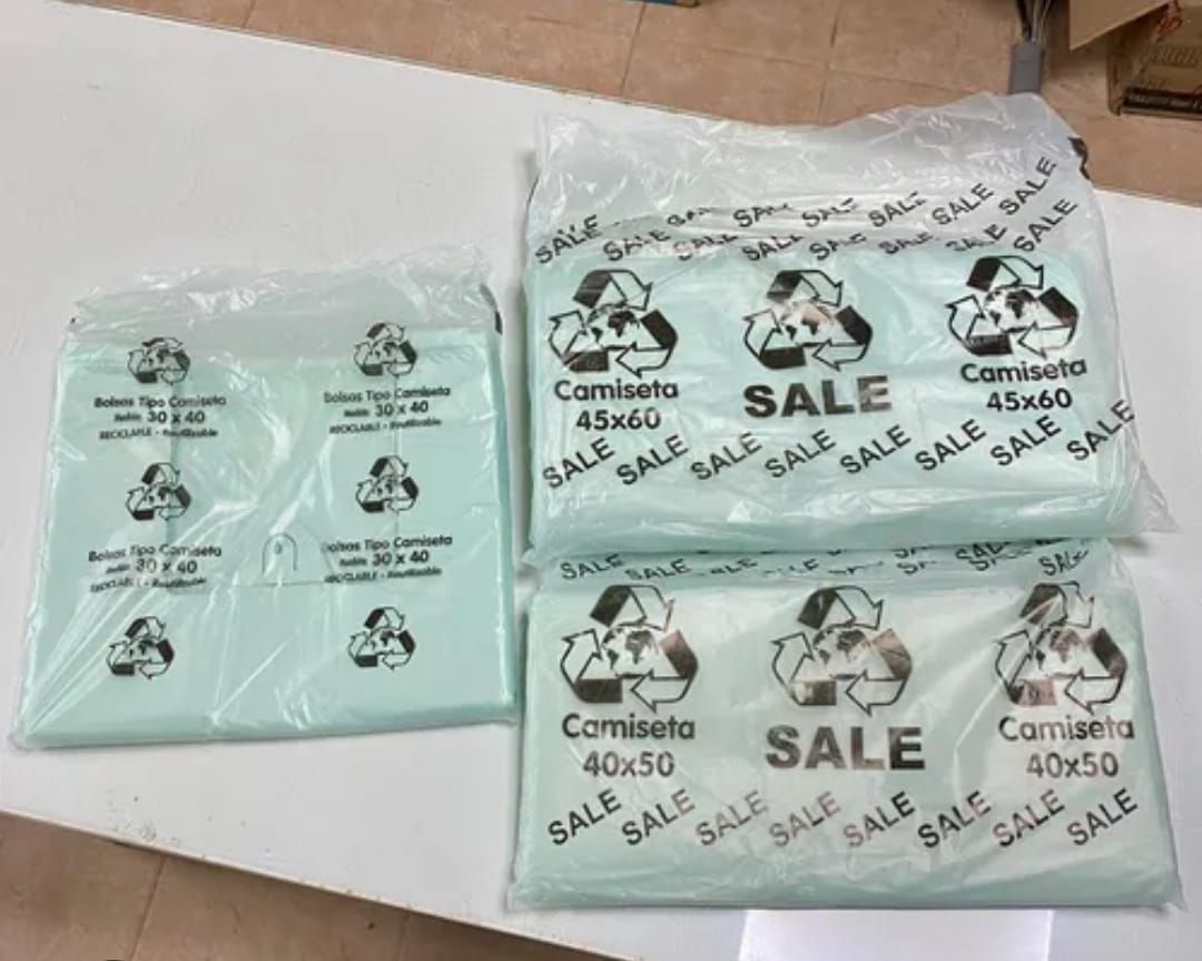 Tres paquetes de bolsas de plástico verde claro con la palabra