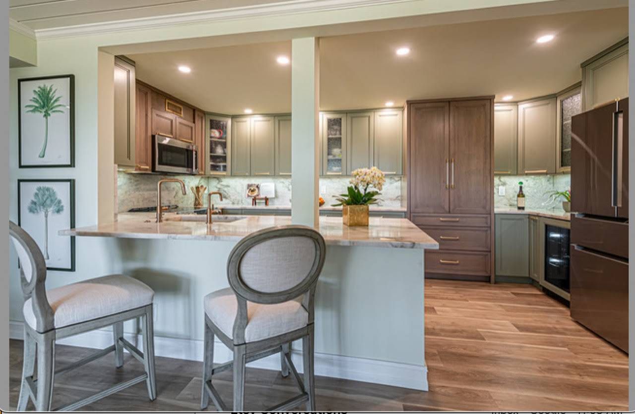A kitchen with a large island and two chairs.