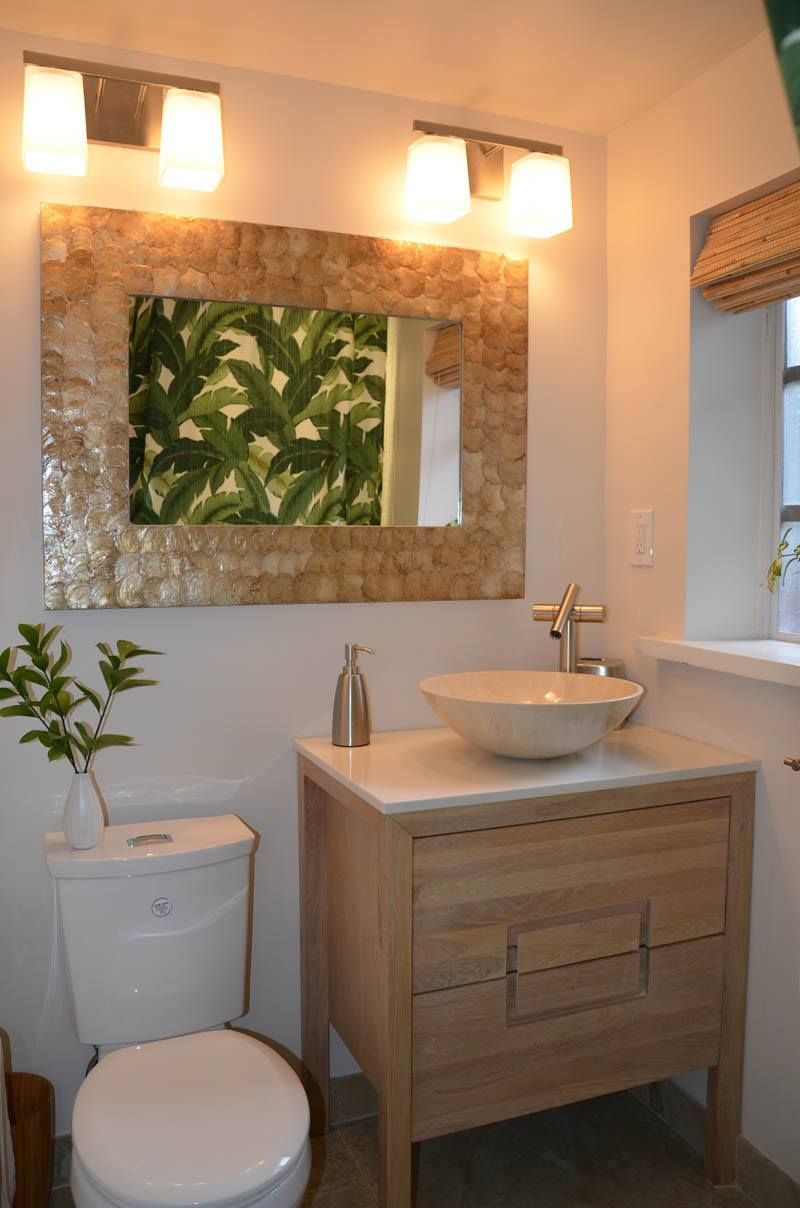 A bathroom with a toilet a sink and a mirror