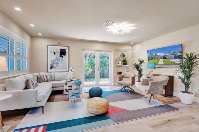 A dining room with a table and chairs and a vase of flowers