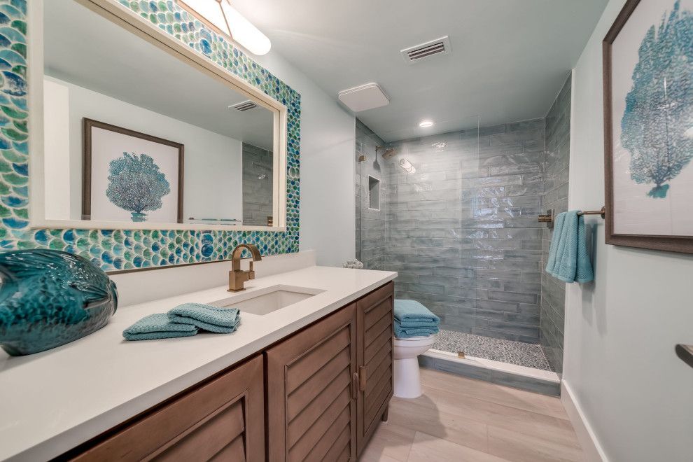 A bathroom with a sink , toilet , shower and mirror.