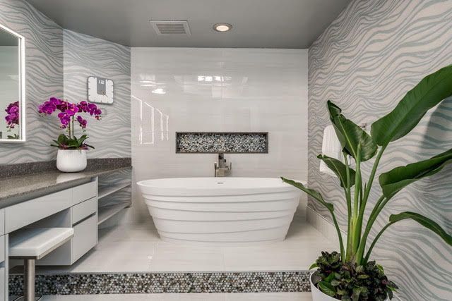 A bathroom with a tub and a plant in it.