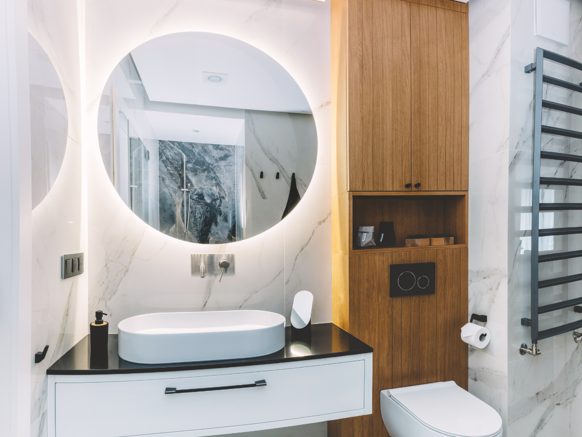 A bathroom with a sink , toilet and mirror.