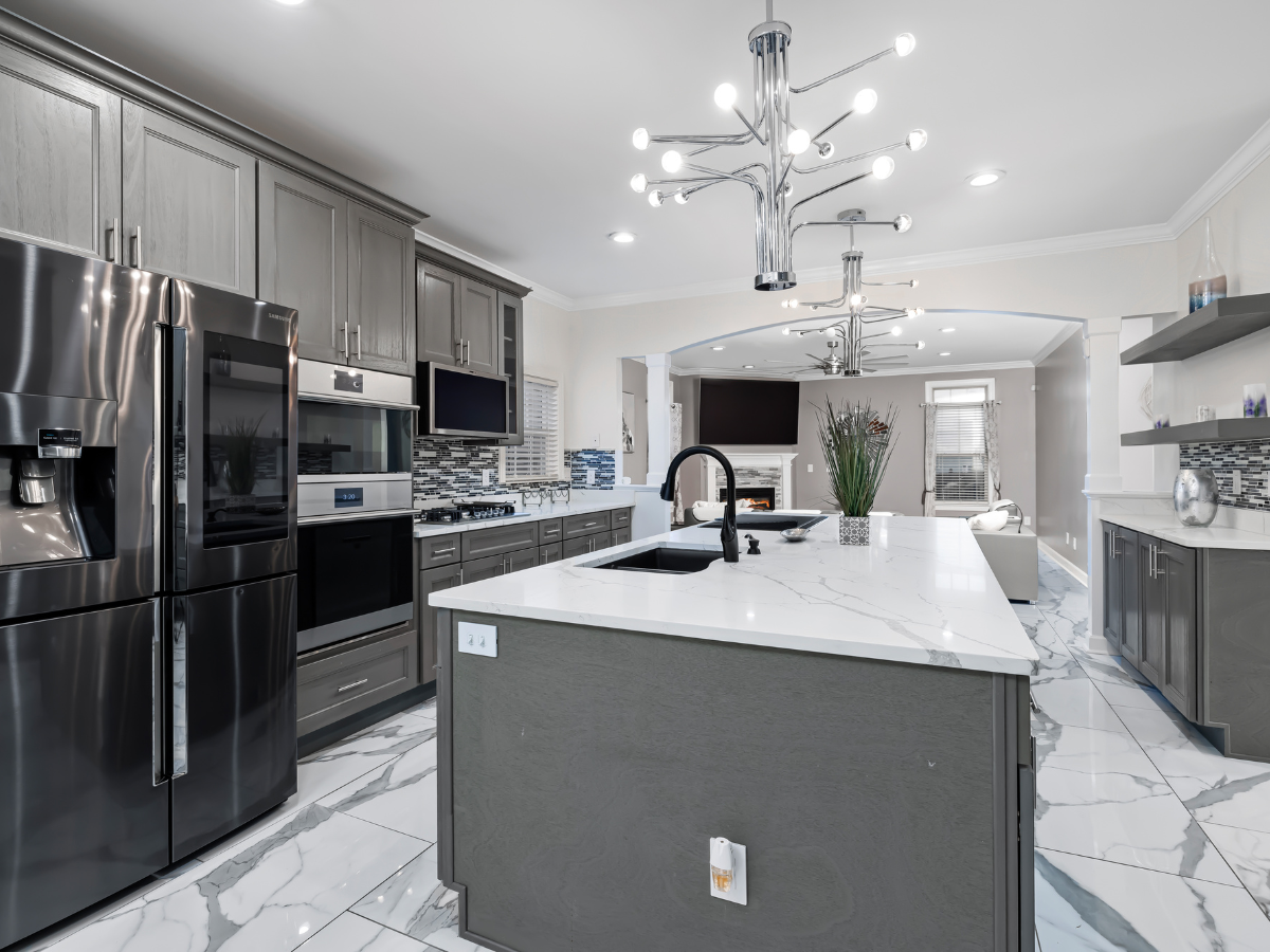 A person measuring a roof with a tape measure A kitchen with stainless steel appliances and a large island.