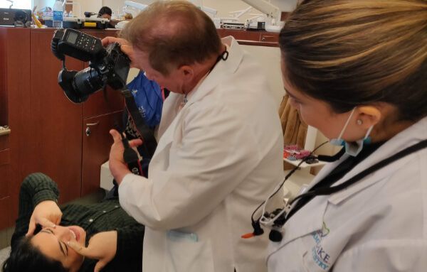 A doctor is taking a picture of a patient with a camera.