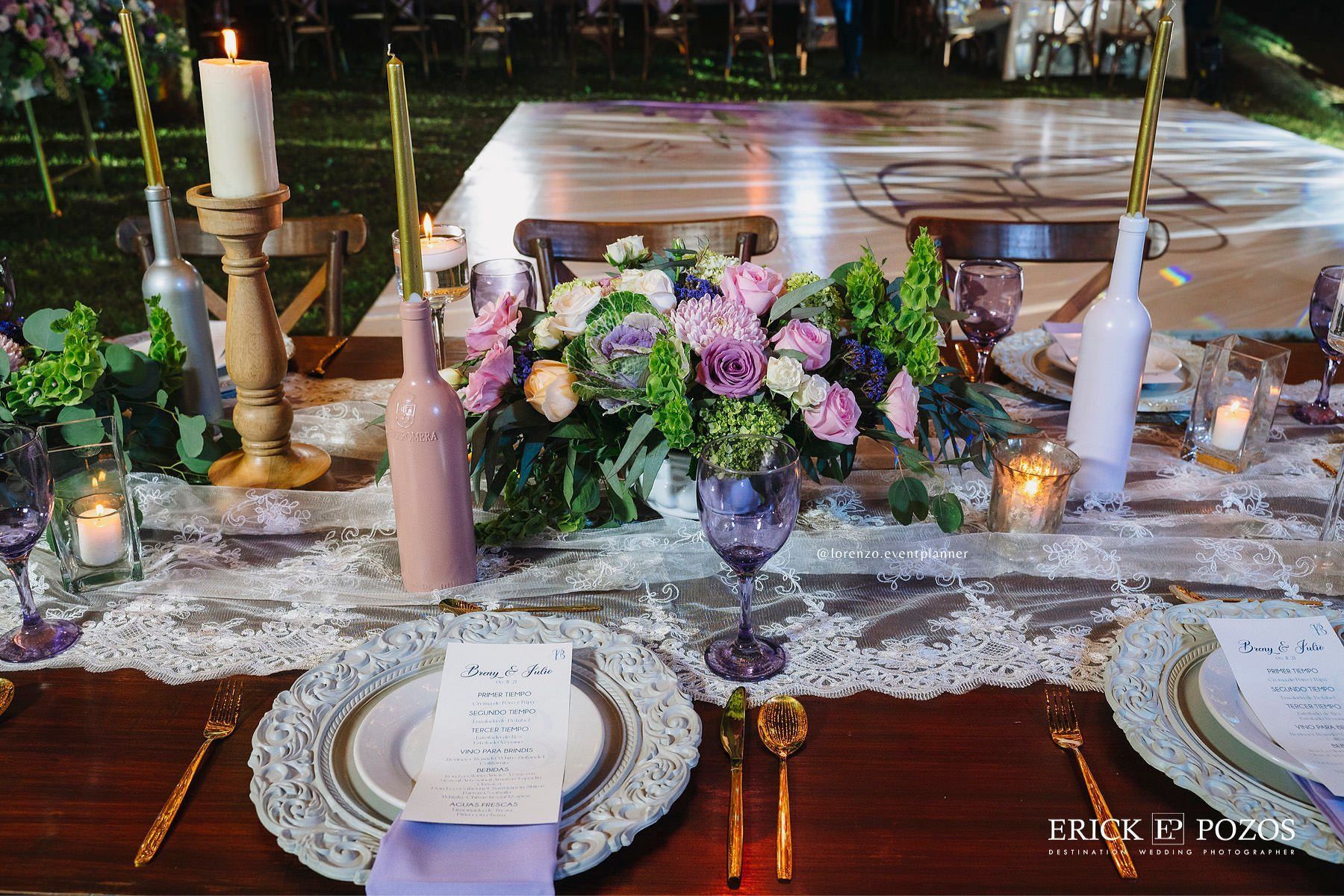 Una mesa con platos, velas y flores sobre ella.