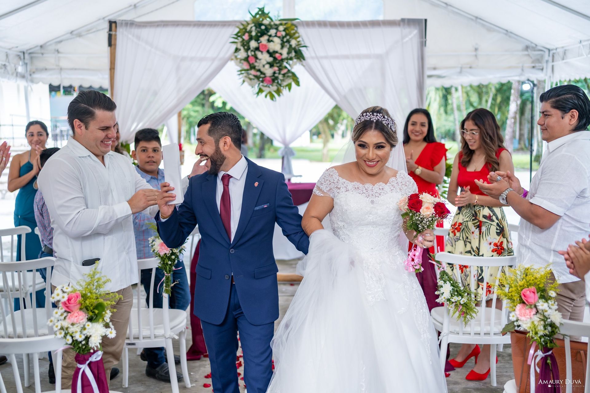 Una novia y un novio caminan hacia el altar en su boda.