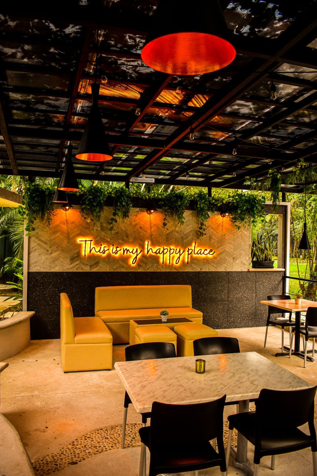 Un restaurante con mesas y sillas y un letrero de neón en la pared.