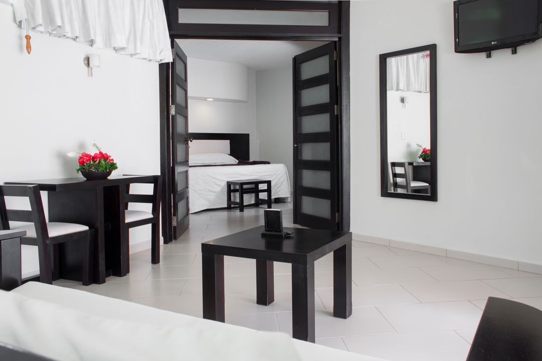 Una habitación de hotel con una mesa y sillas y una cama.