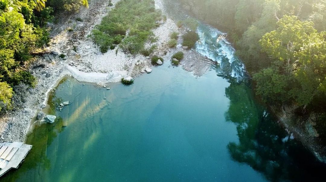 Una vista aérea de un río rodeado de árboles y rocas.