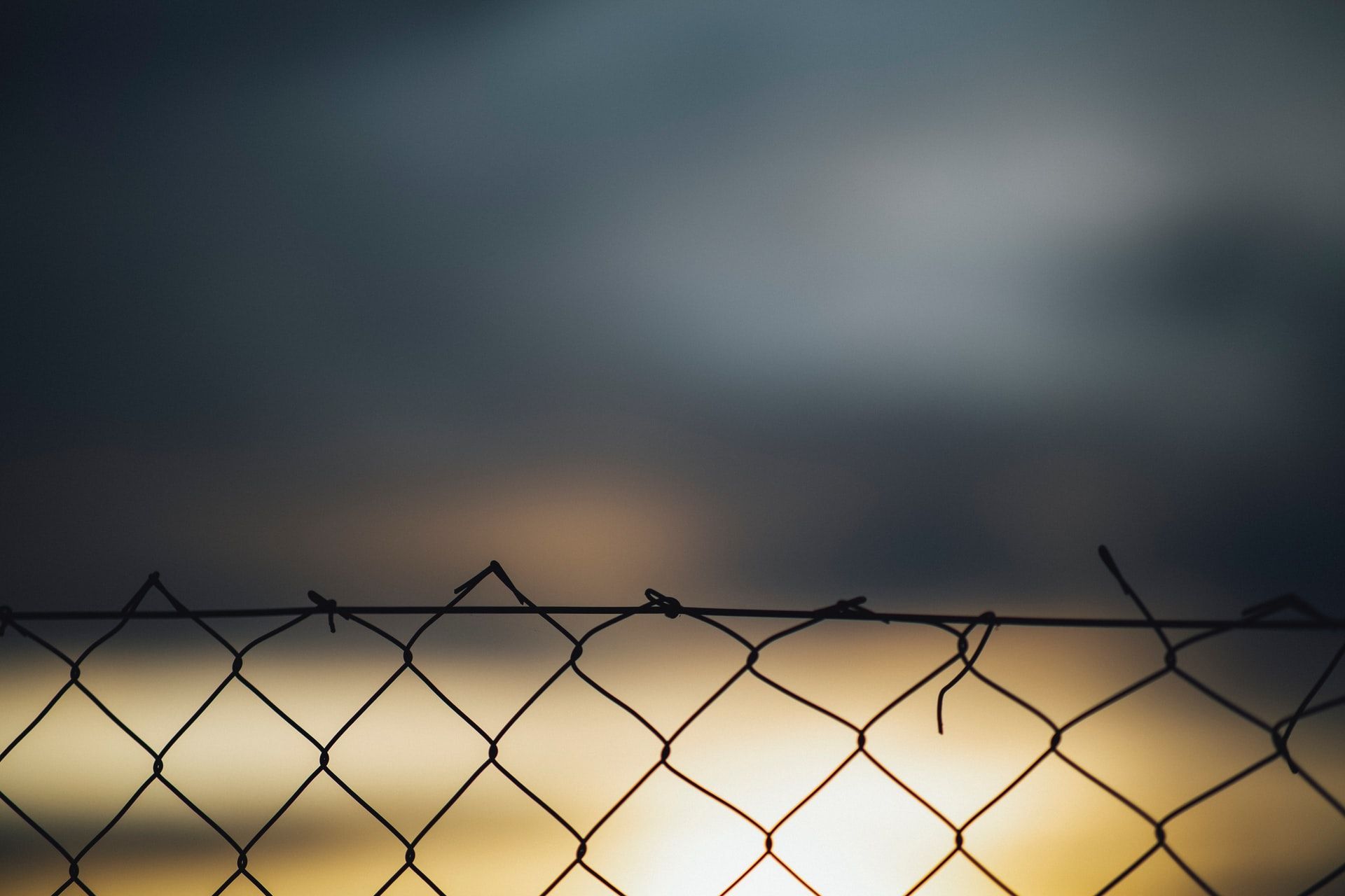 A close up of a chain link fence with a blurred background.