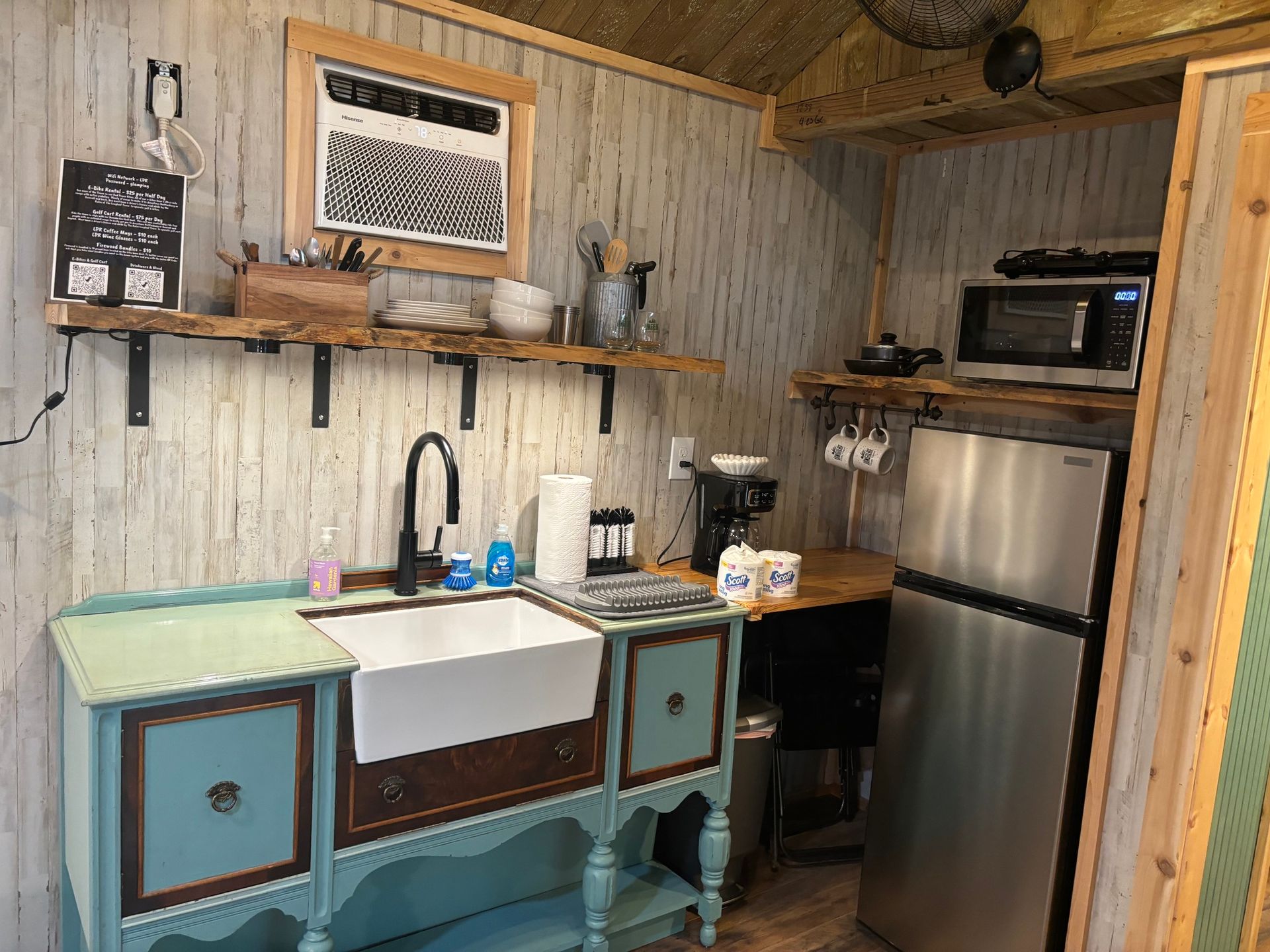 A kitchen with a sink , refrigerator and microwave.