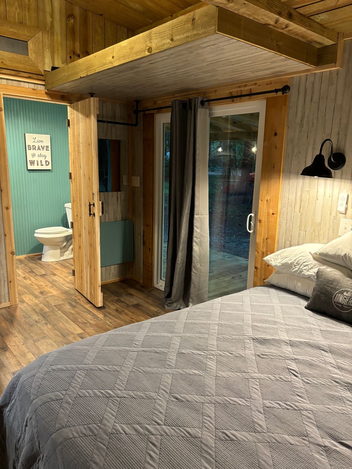 A bedroom with a bed , toilet , and bathroom.