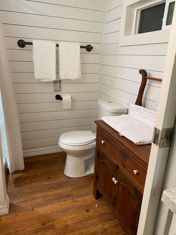 A bathroom with a toilet , sink , and window.