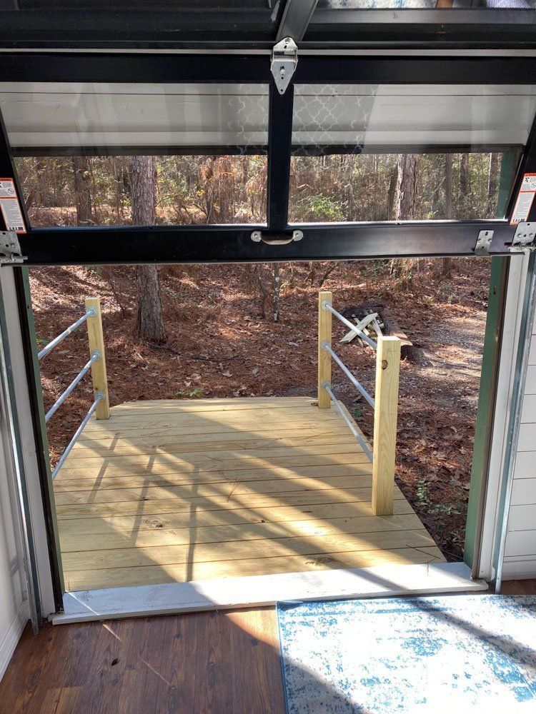 A view of a wooden deck from inside a garage door.
