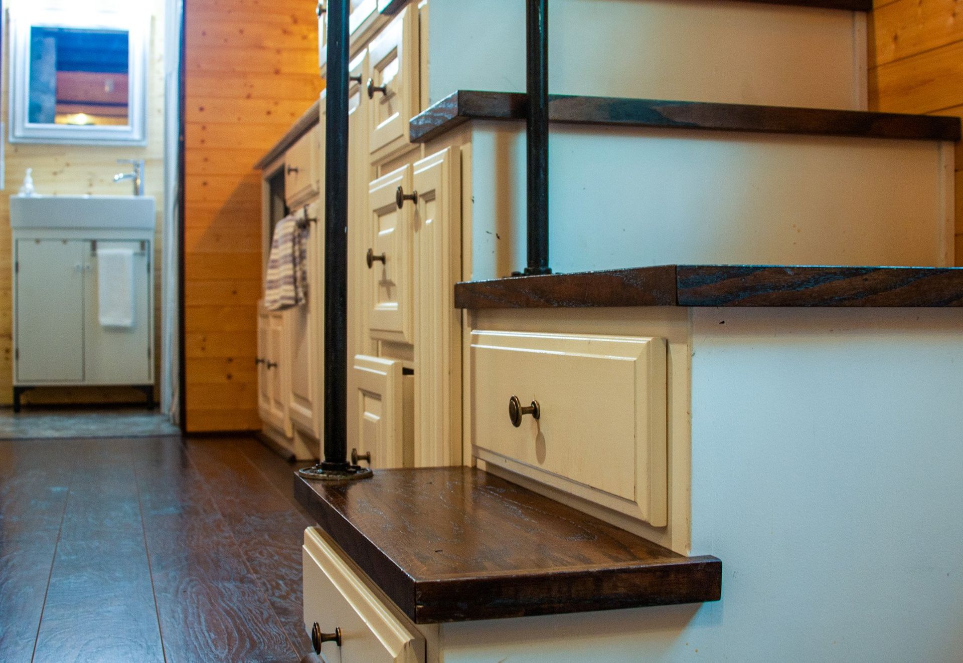 The stairs are made of wood and have drawers underneath them.