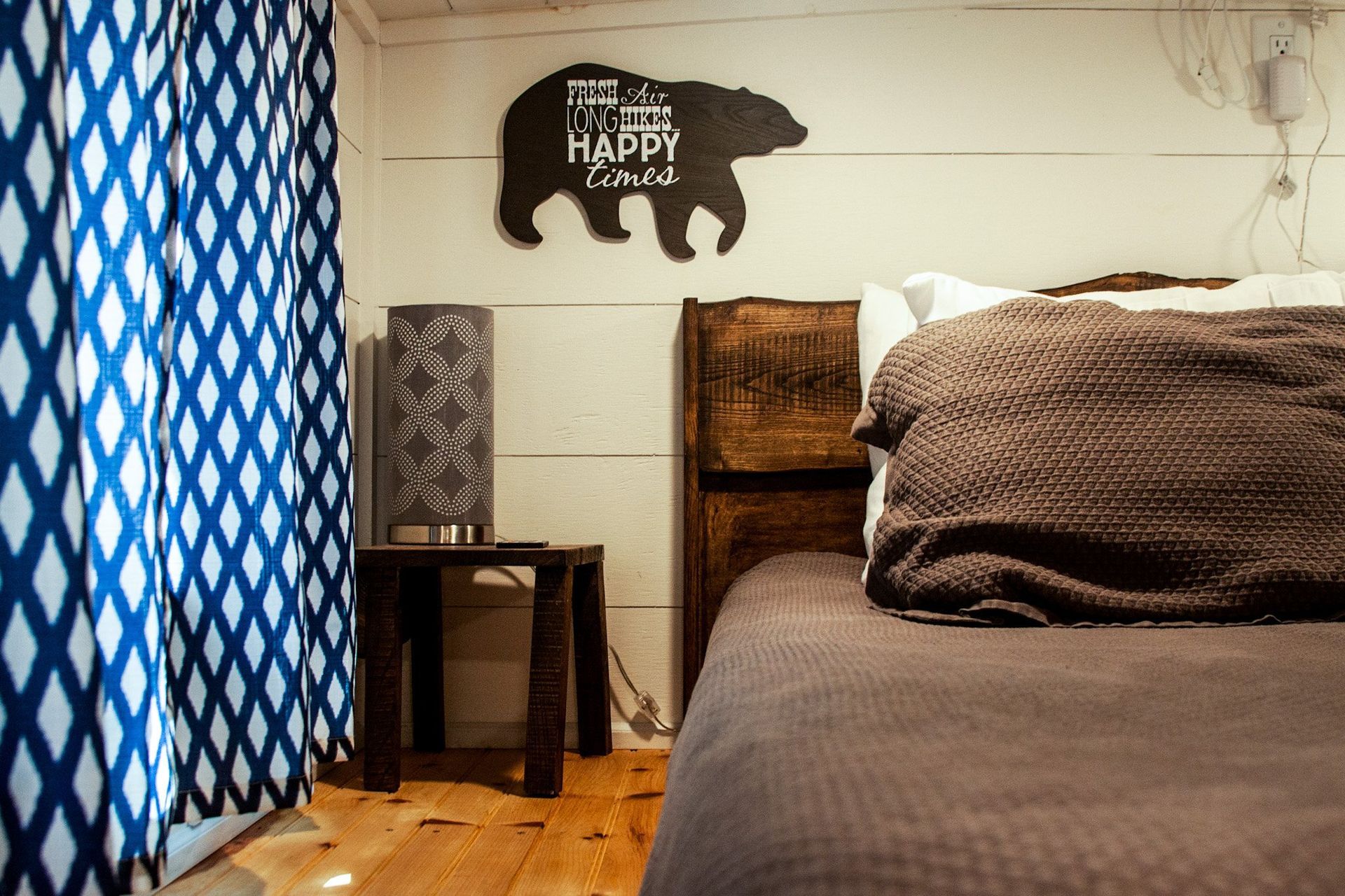 A bedroom with a bed and a sign on the wall that says 
