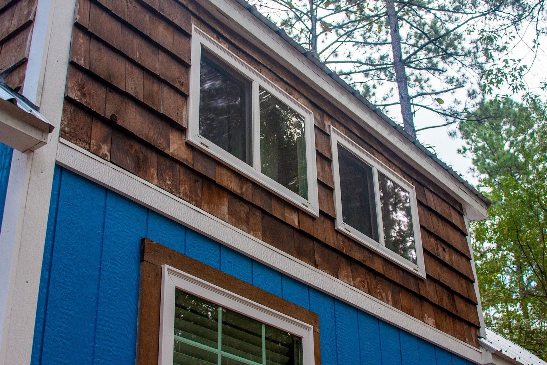 A blue and brown house with a lot of windows