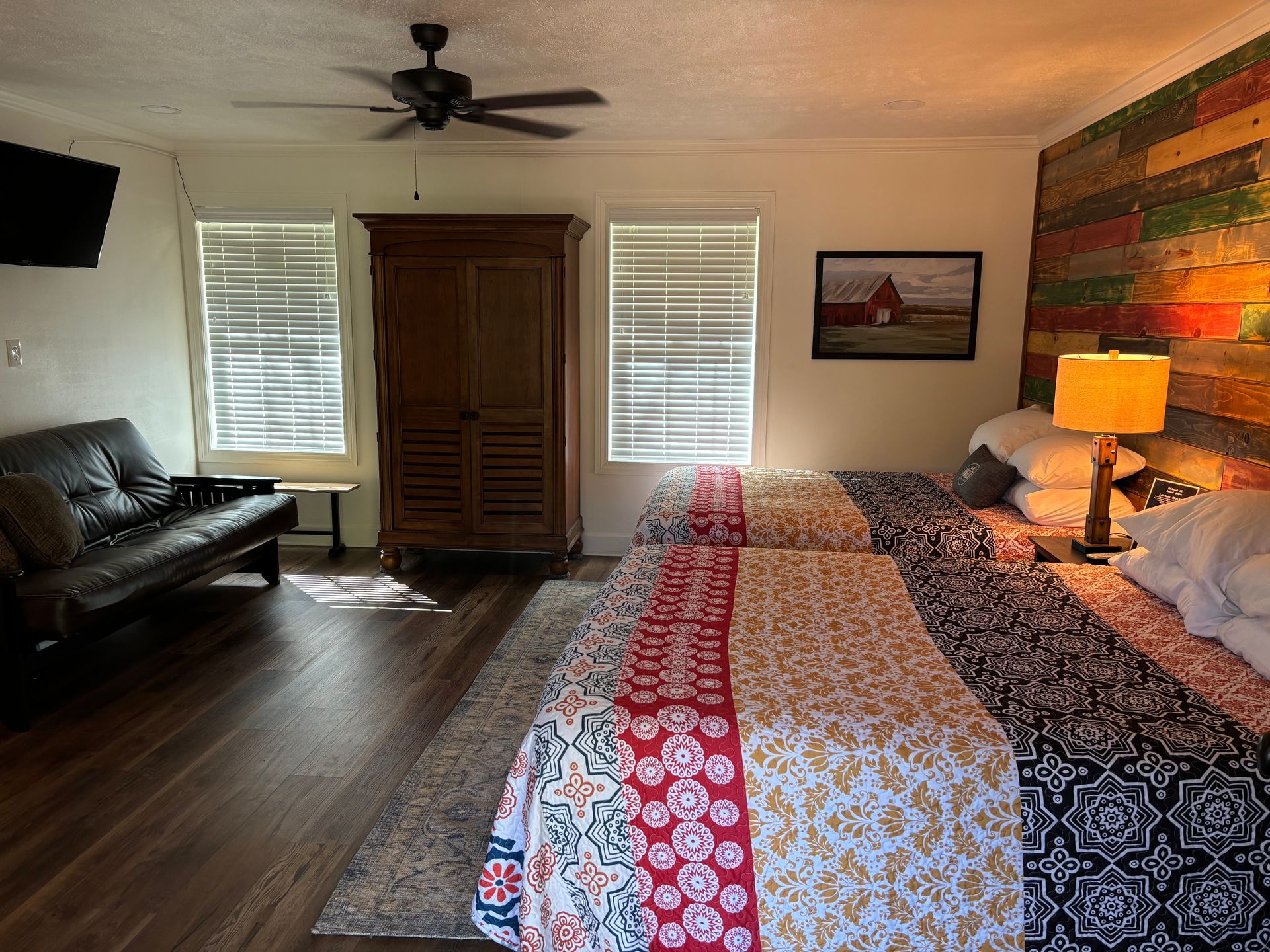 A hotel room with two beds and a futon.