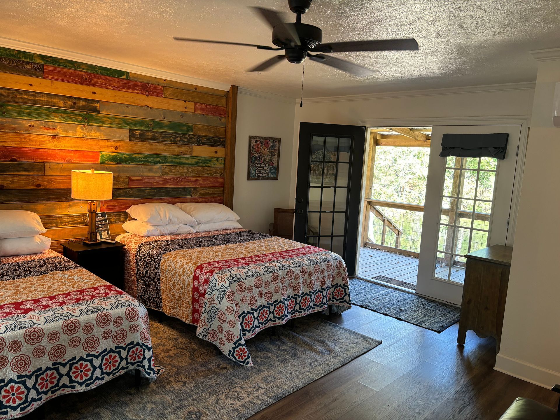 A bedroom with two beds and a ceiling fan.