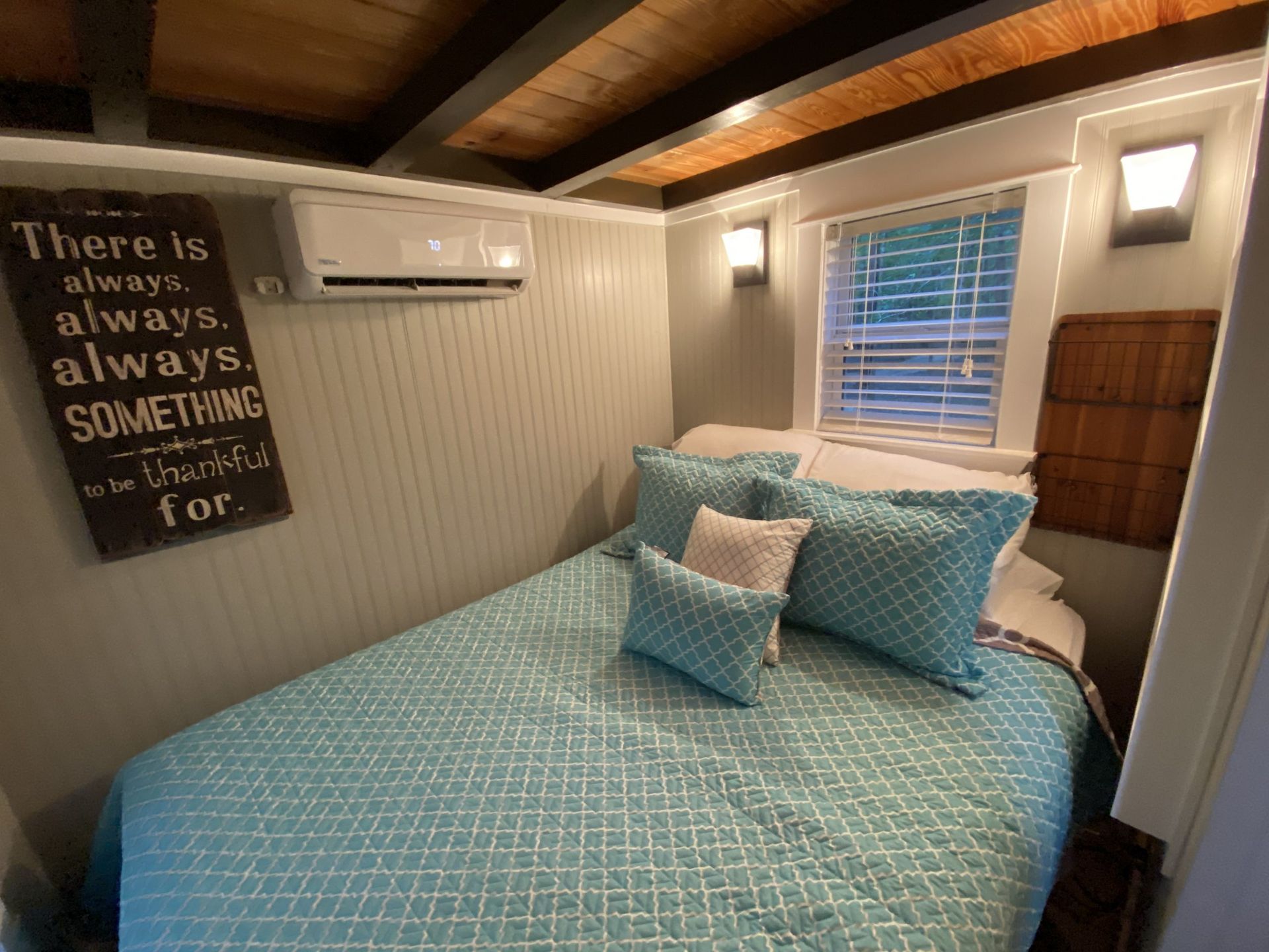 A bedroom with a bed and a sign that says `` there is always always always something for ''.