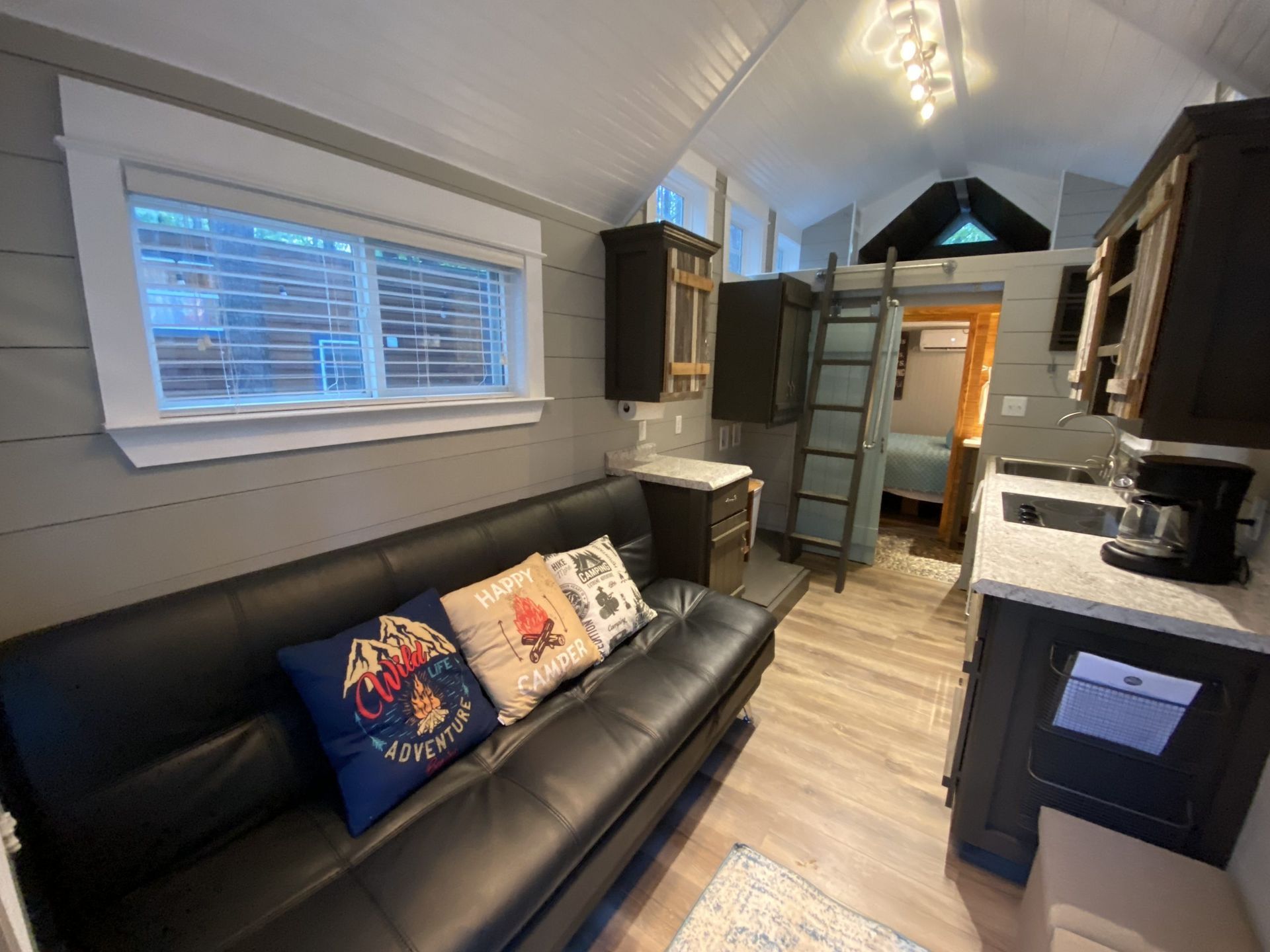 A living room with a couch and a kitchen in a small house.