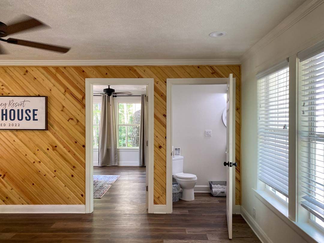 A room with wood paneling and a sign that says house