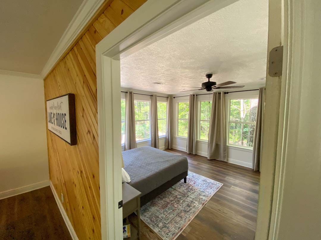 A bedroom with a large bed and a ceiling fan.