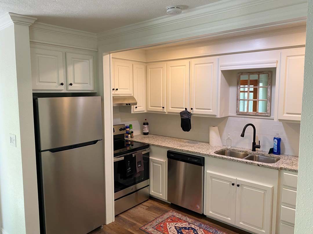 A kitchen with white cabinets and stainless steel appliances.