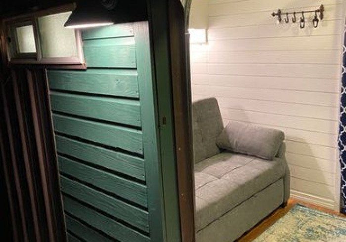 A couch is sitting in a room next to a door.
