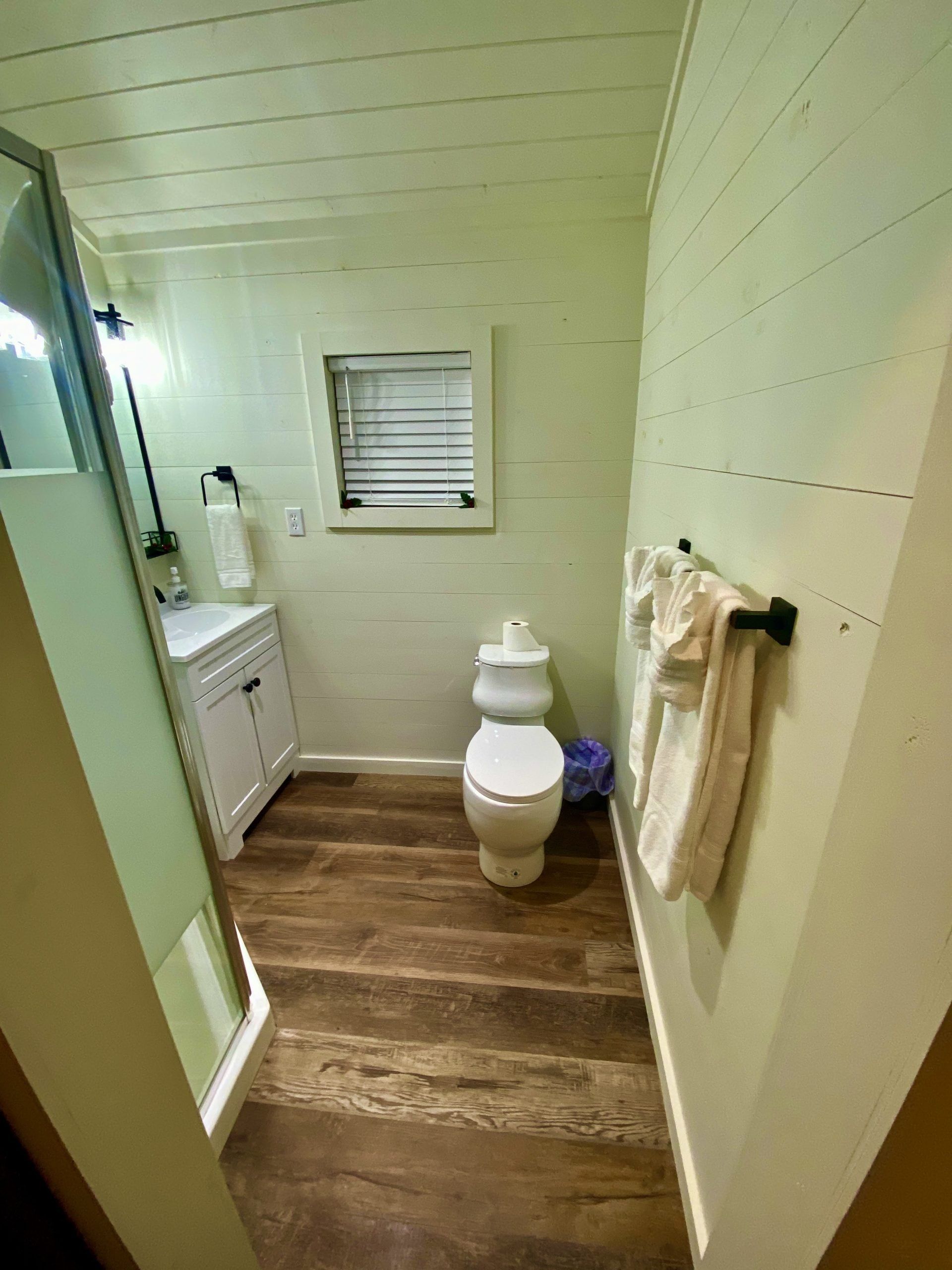 A bathroom with a toilet , sink , and shower.