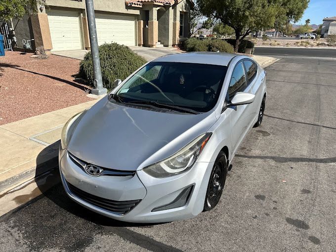 A silver hyundai elantra is parked on the side of the road