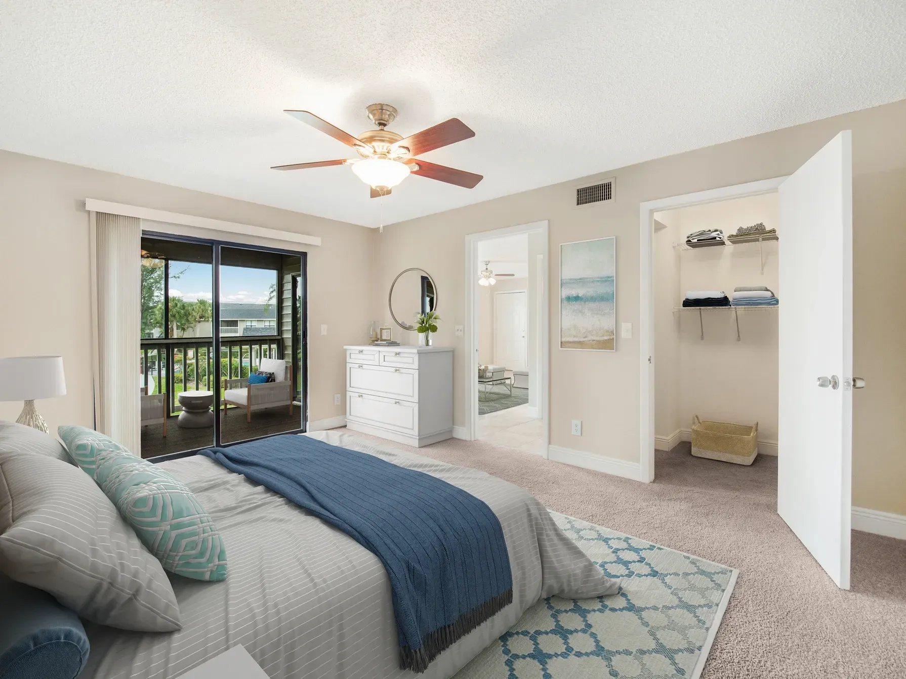 A bedroom with a large bed and a ceiling fan.