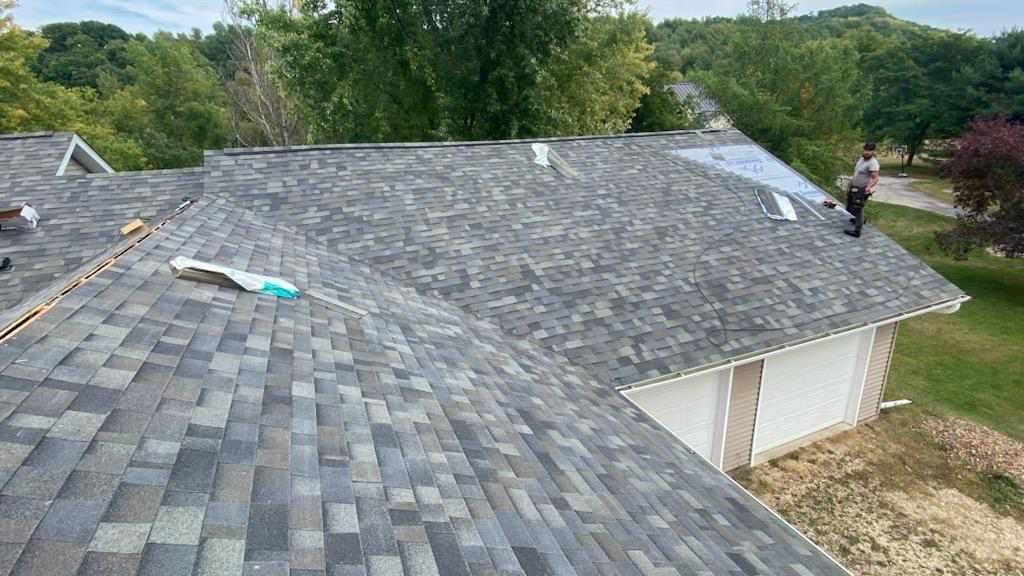 A man is working on the roof of a house.