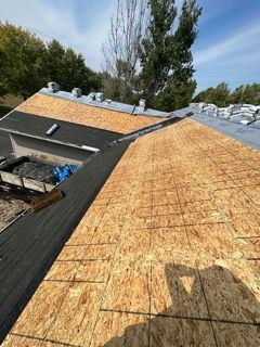 A roof is being replaced with plywood and shingles.