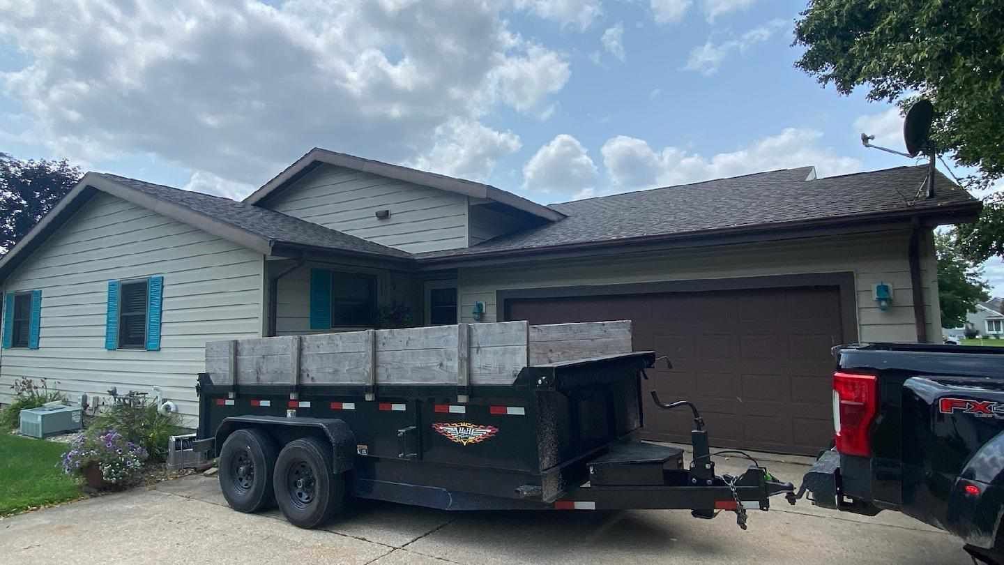 new roof installed by Curti Construction in La Crosse, WI with dump trailer and truck 