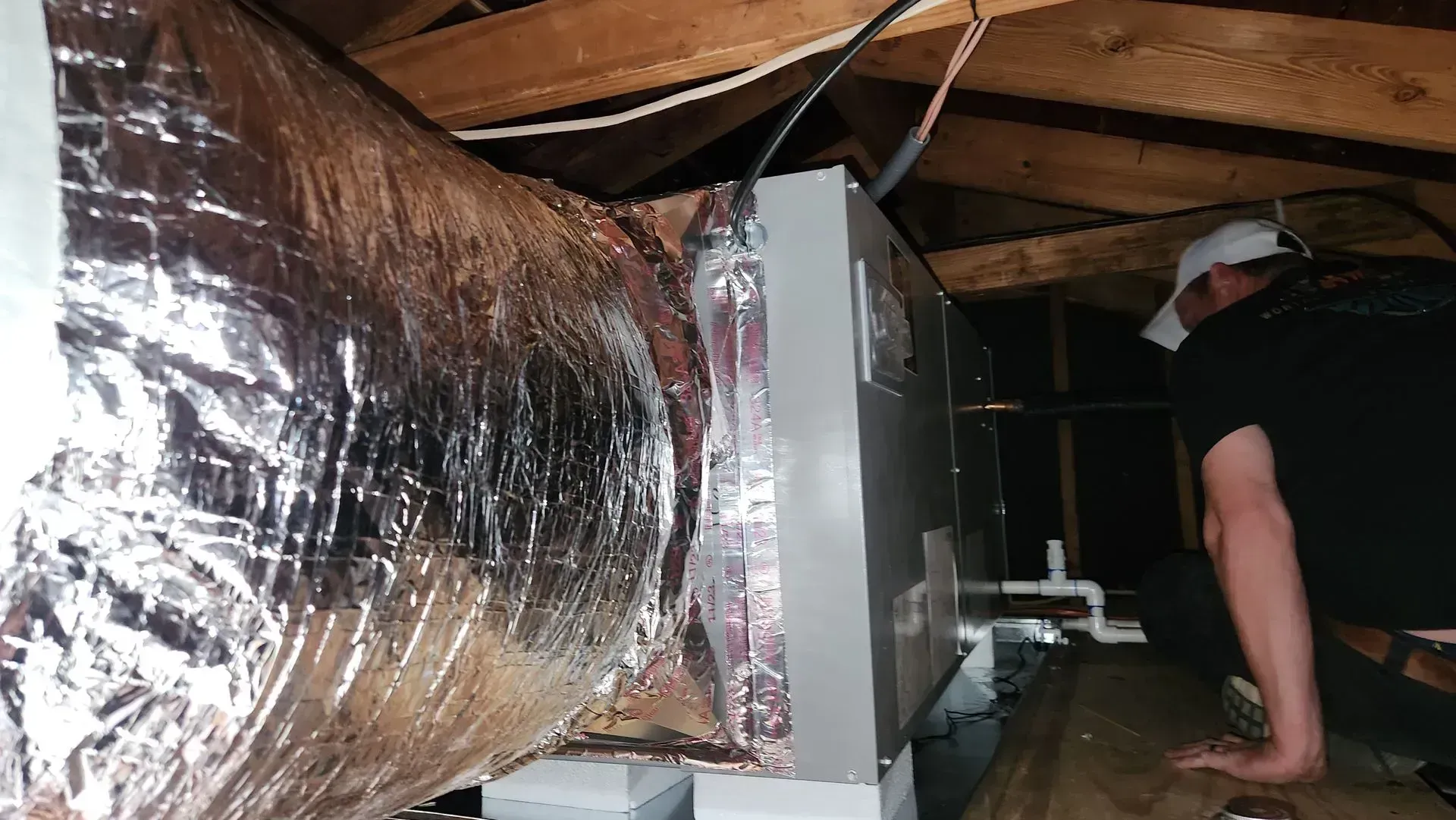 White house exterior with AC unit, white gutters, and small shrubbery.