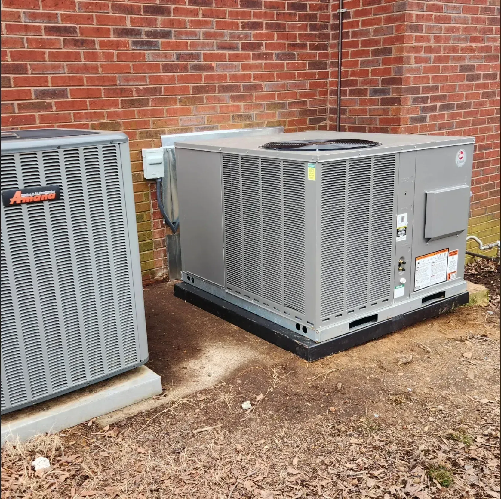 White house exterior with AC unit, white gutters, and small shrubbery.