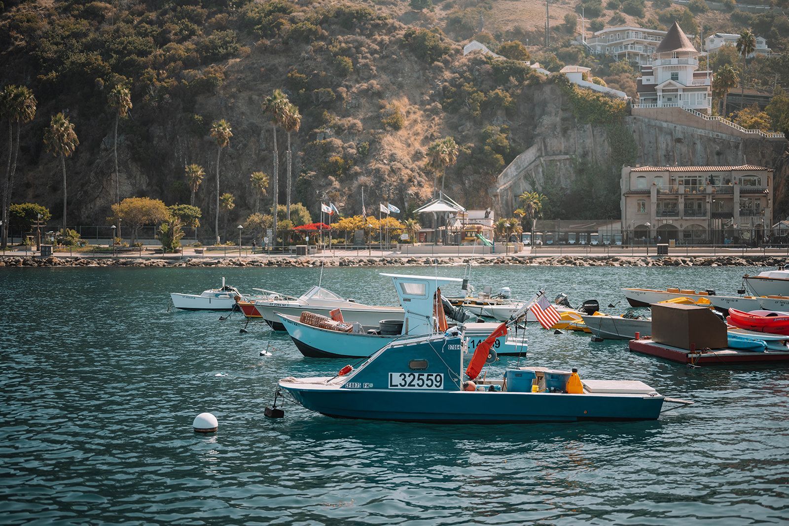 a group of boats are floating on top of a body of water .