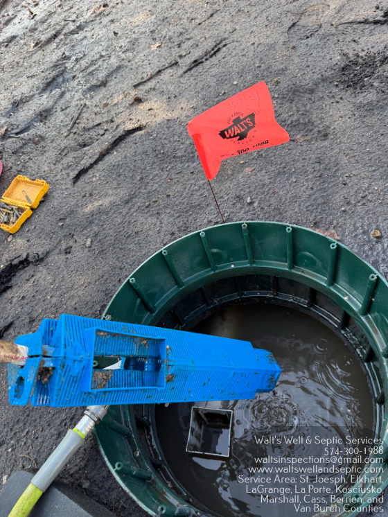 Construction site with workers installing a septic system in a trench, snow on the ground.