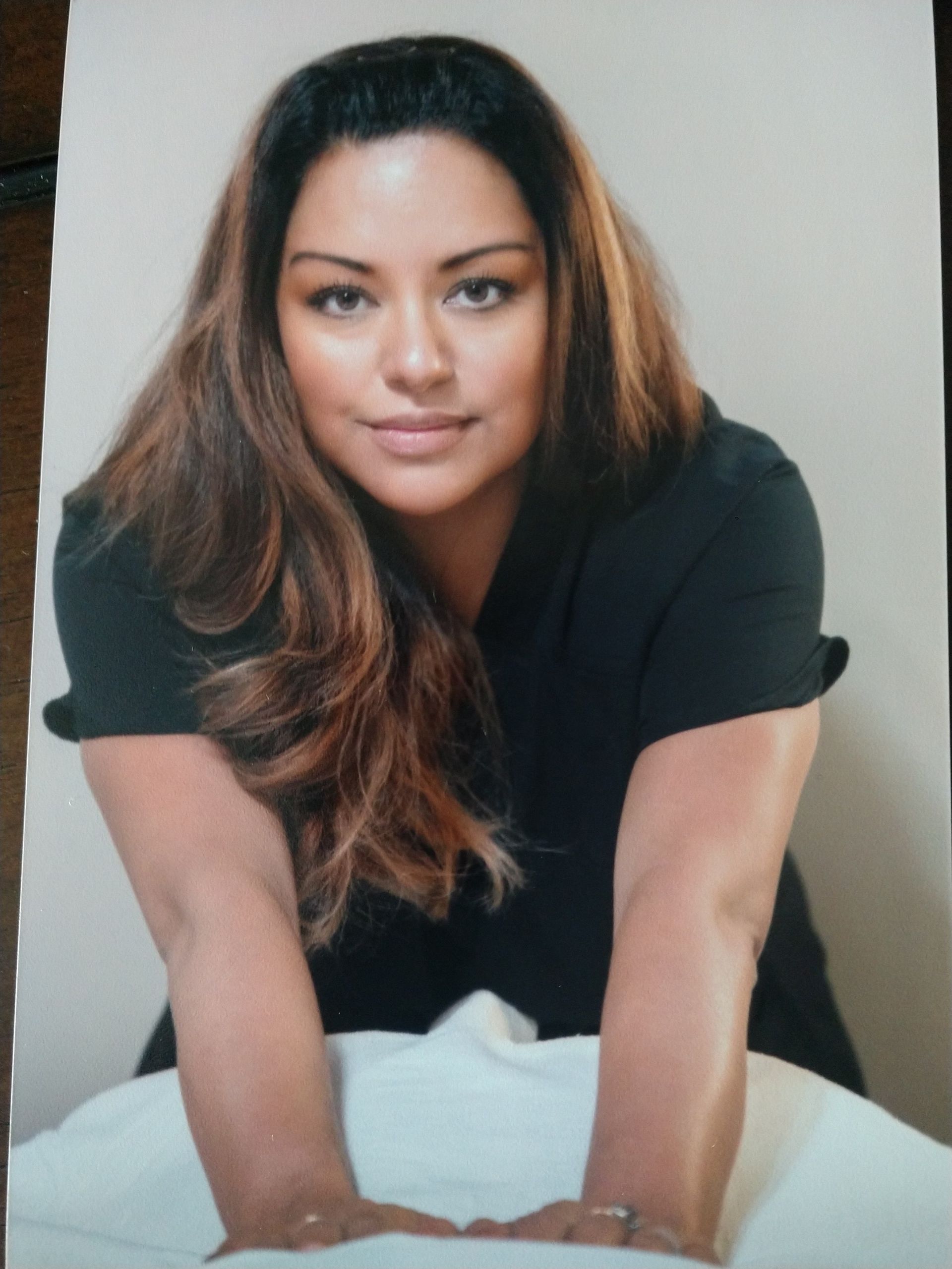 A woman in a black shirt is kneeling on a table