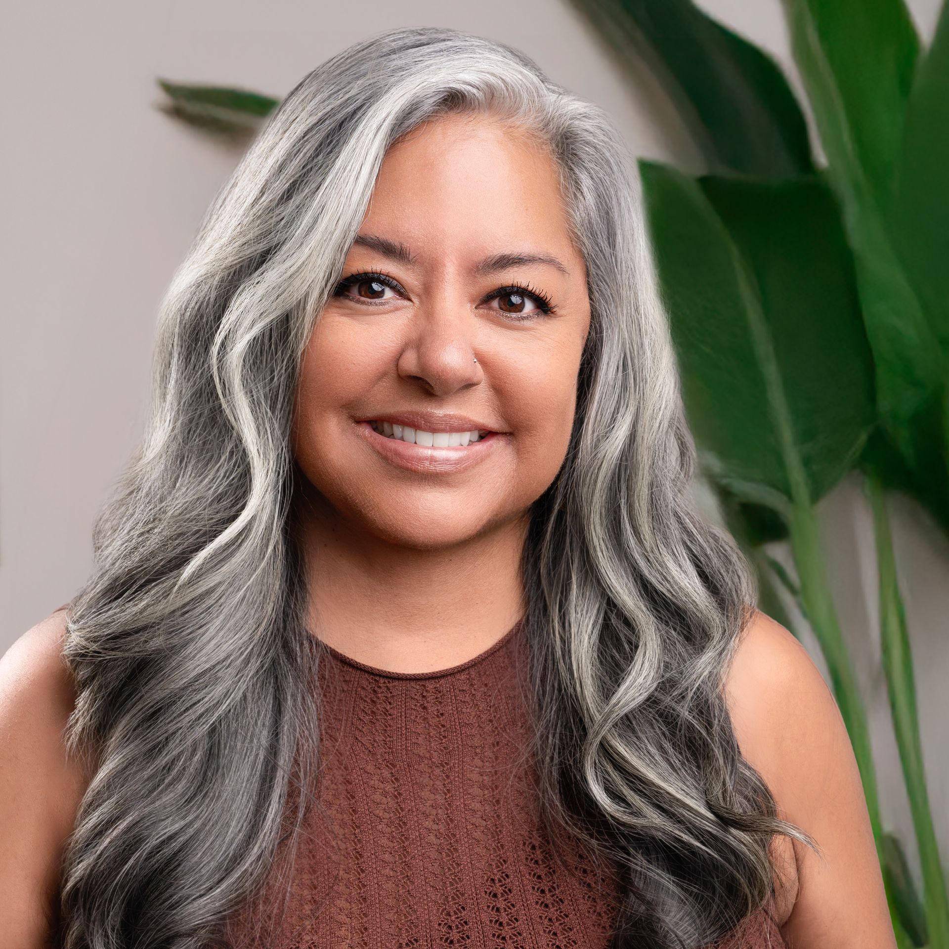 A woman with long hair is smiling in a black and white photo.