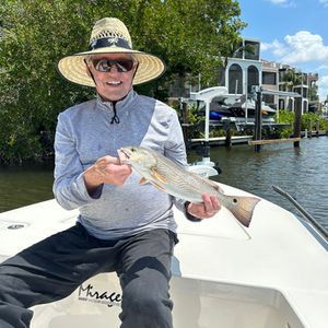 A man is sitting on a boat holding a fish.