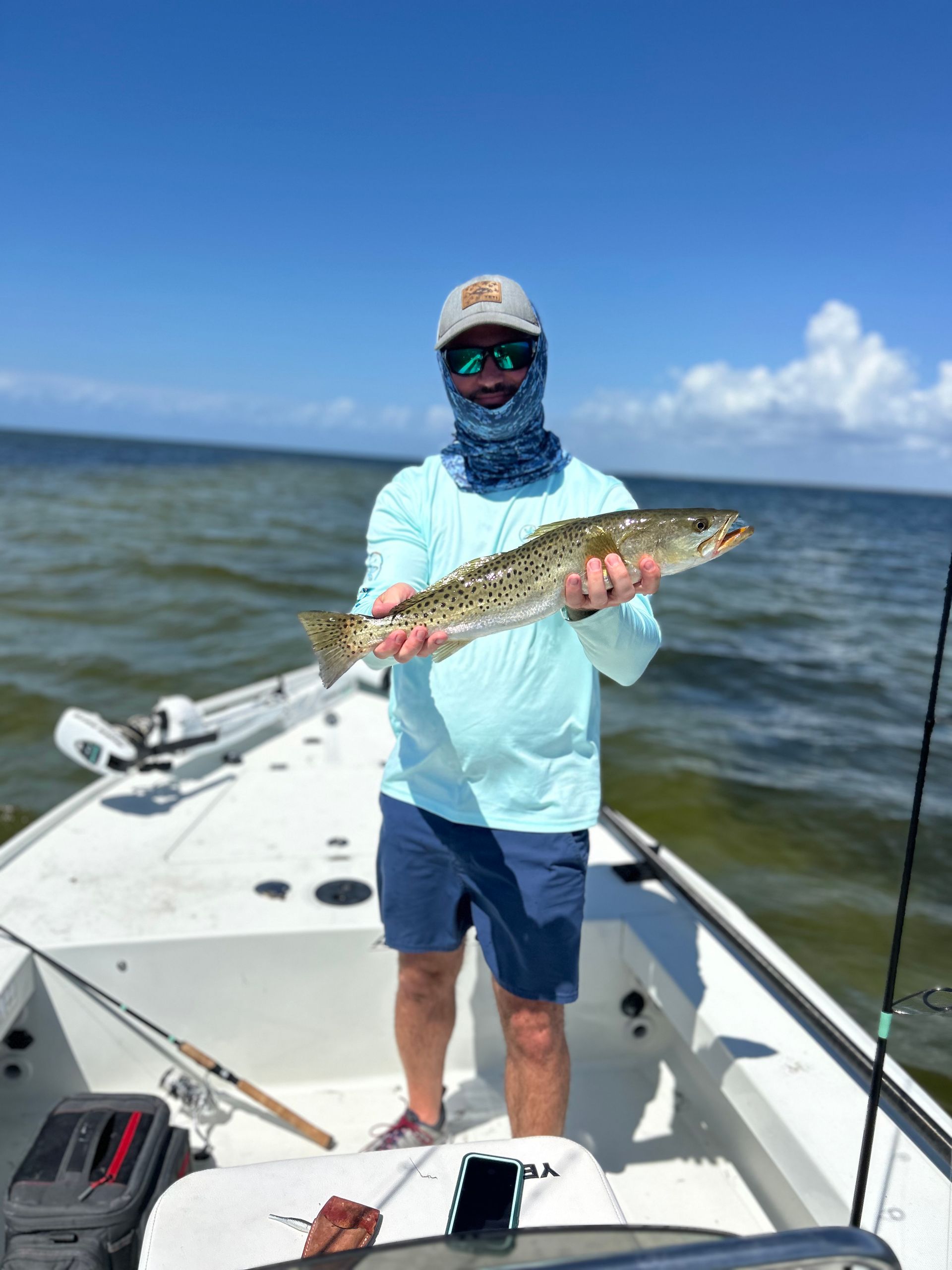 A man is standing on a boat holding a fish.