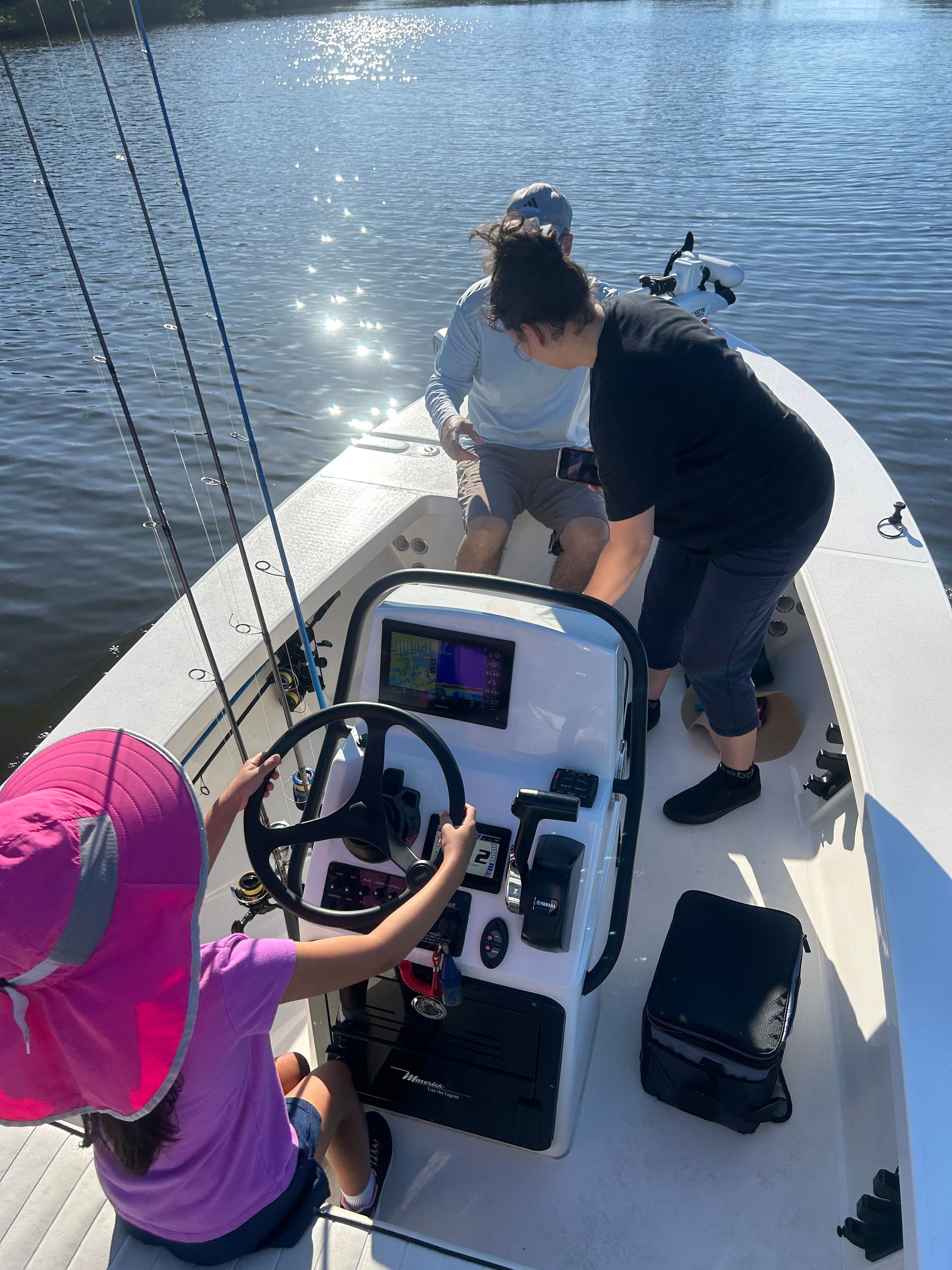 A man and a little girl are sitting on a boat in the water.